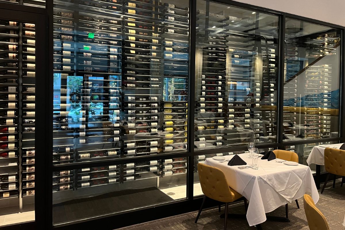 Custom glass enclosed wine cellar design by Millesime