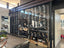 Glass enclosed residential dining room wine cellar with display shelves and label display shelves